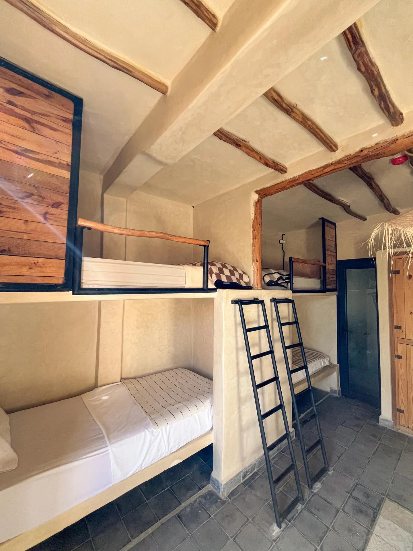 Shared room with lofted beds, wooden beams and two ladders