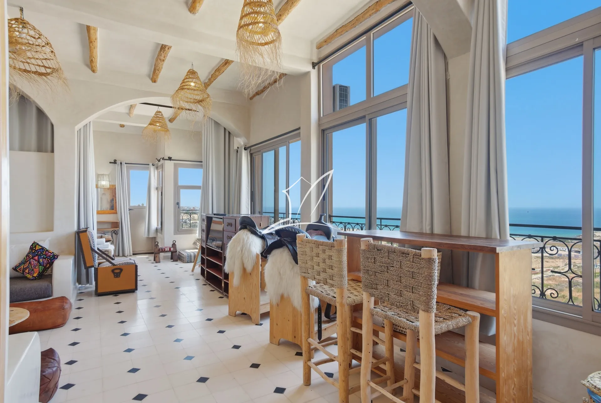 Lounge with tall windows looking out over the sea