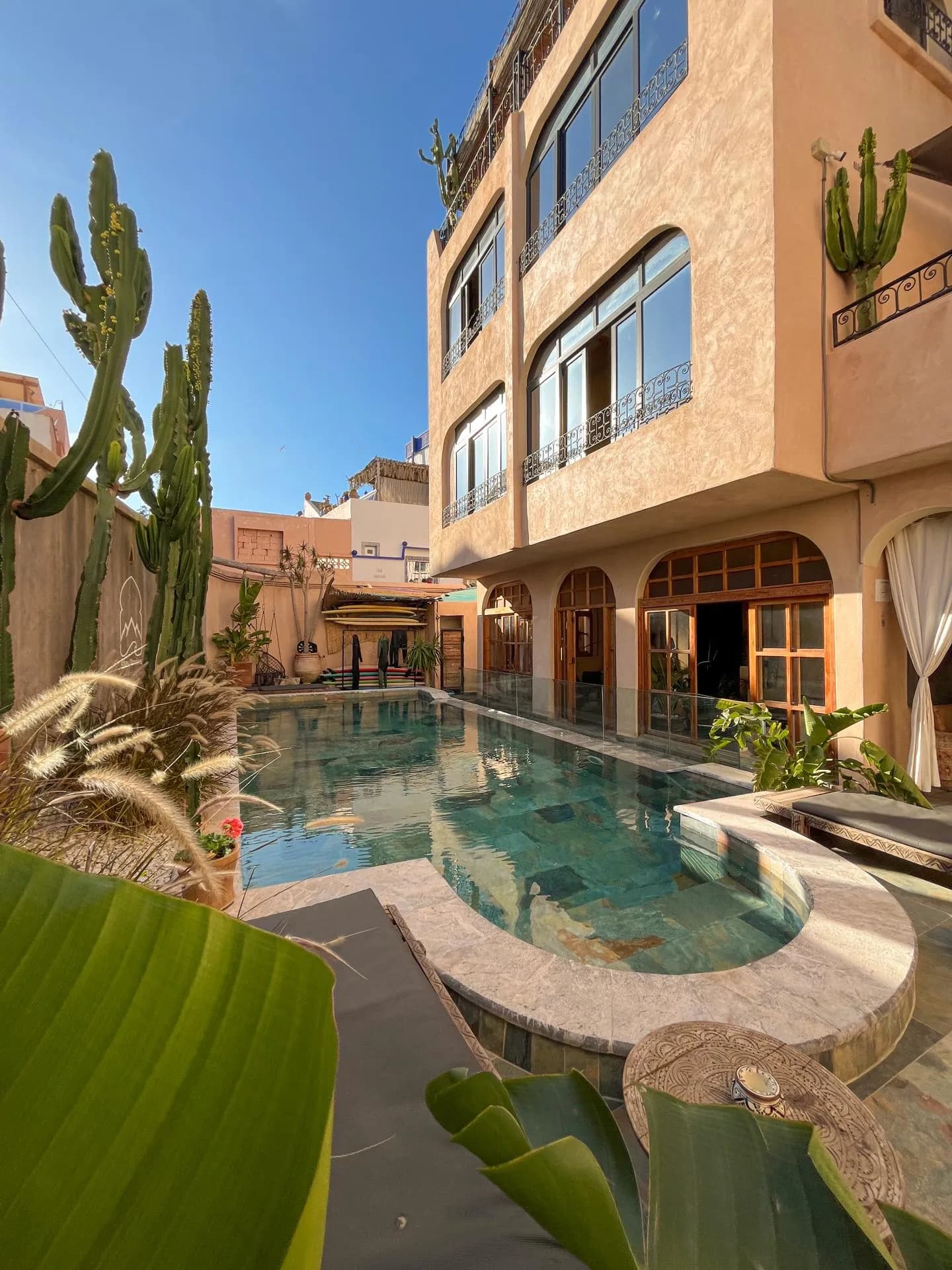 Riad building with arched windows around a pool