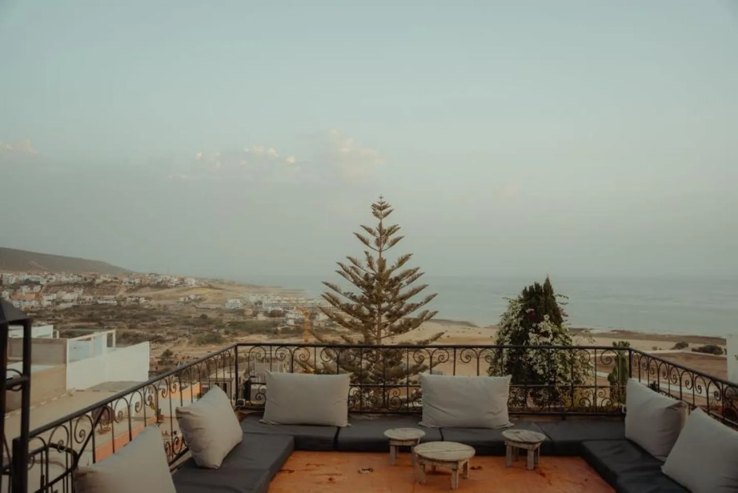 Rooftop terrace lounge with cushions overlooking the coast