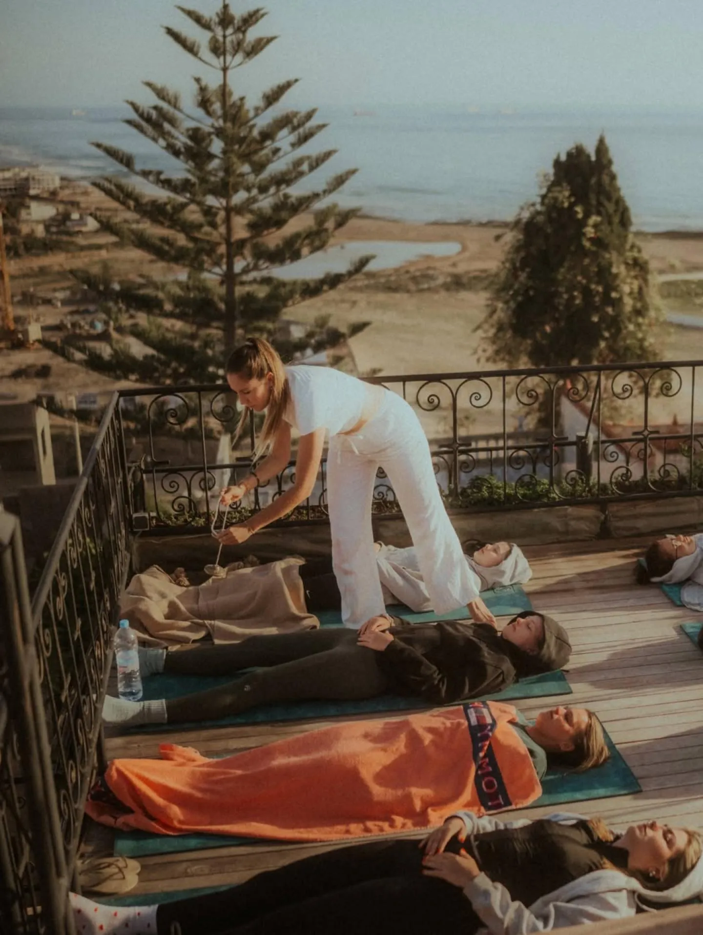 Yoga teacher guiding a session on a rooftop terrace