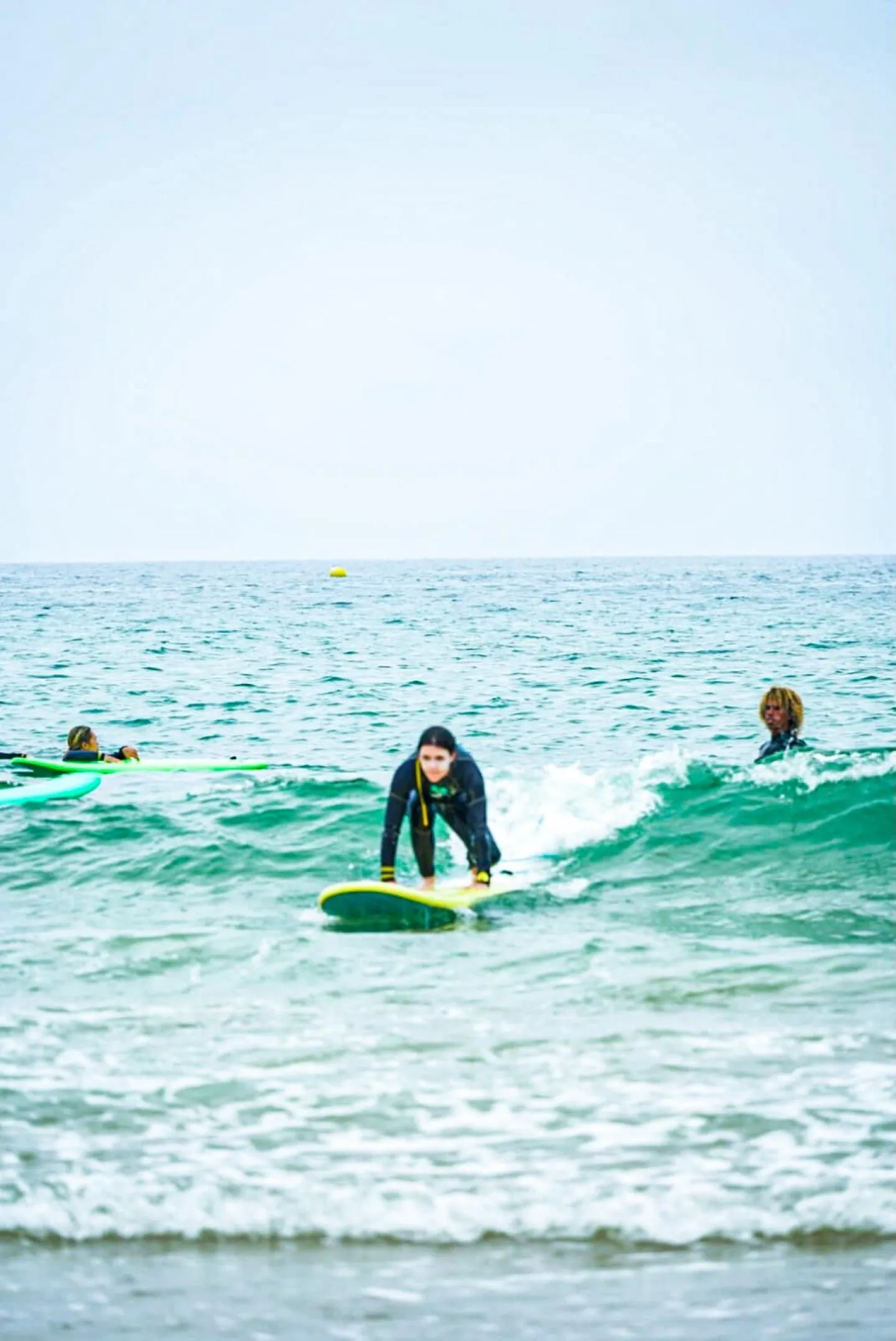 Surfer standing up on a board in turquoise whitewater